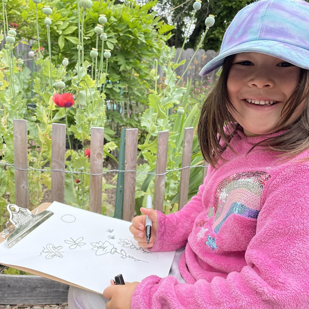 girl drawing in garden