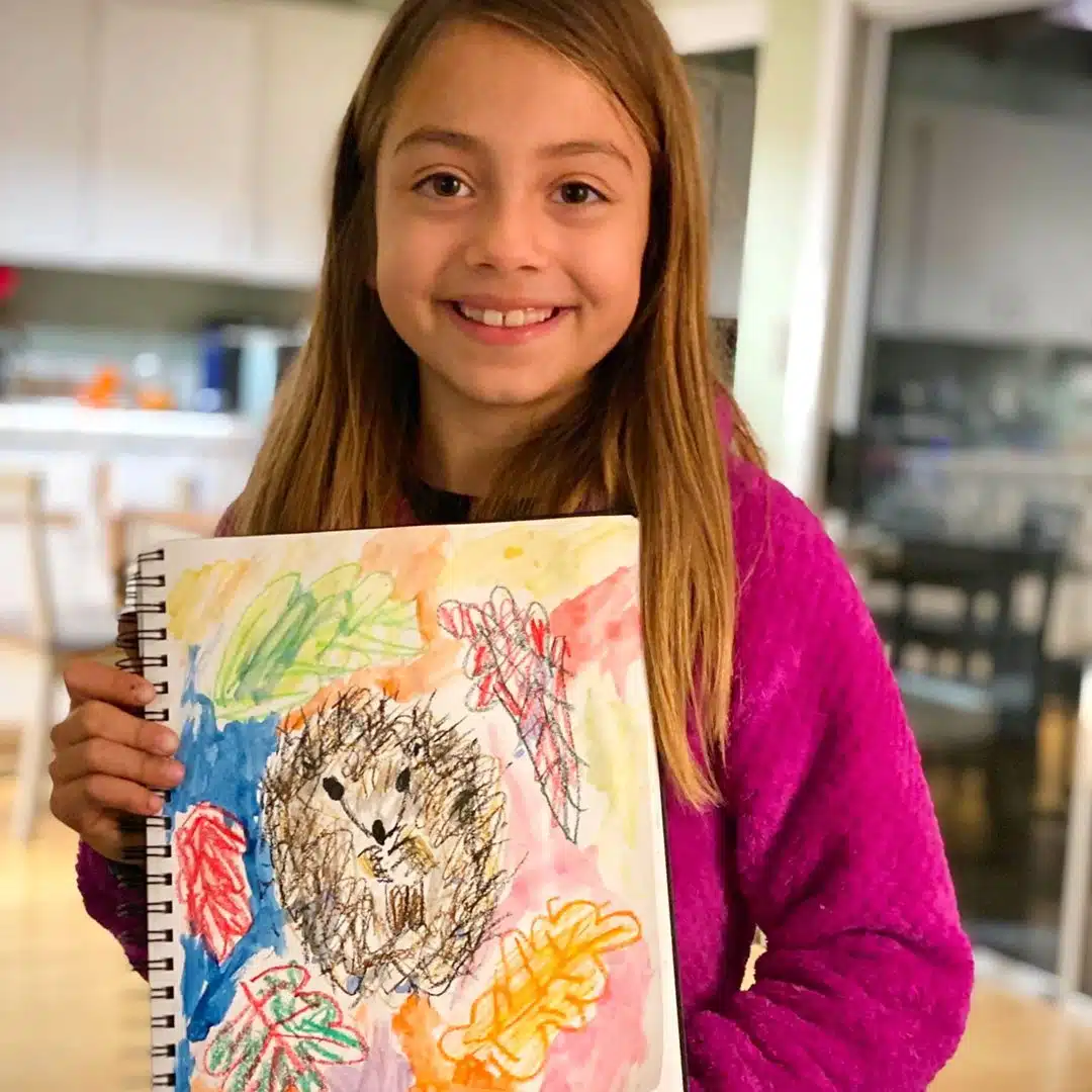 child showing her artwork